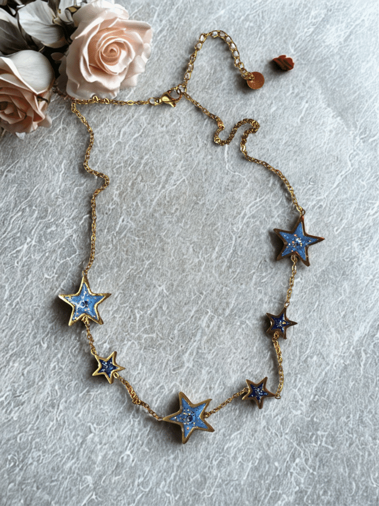 Collier étoile bleu pailleté, doré Éclat Stellaire en acier inoxydable avec étoiles scintillantes sur fond clair