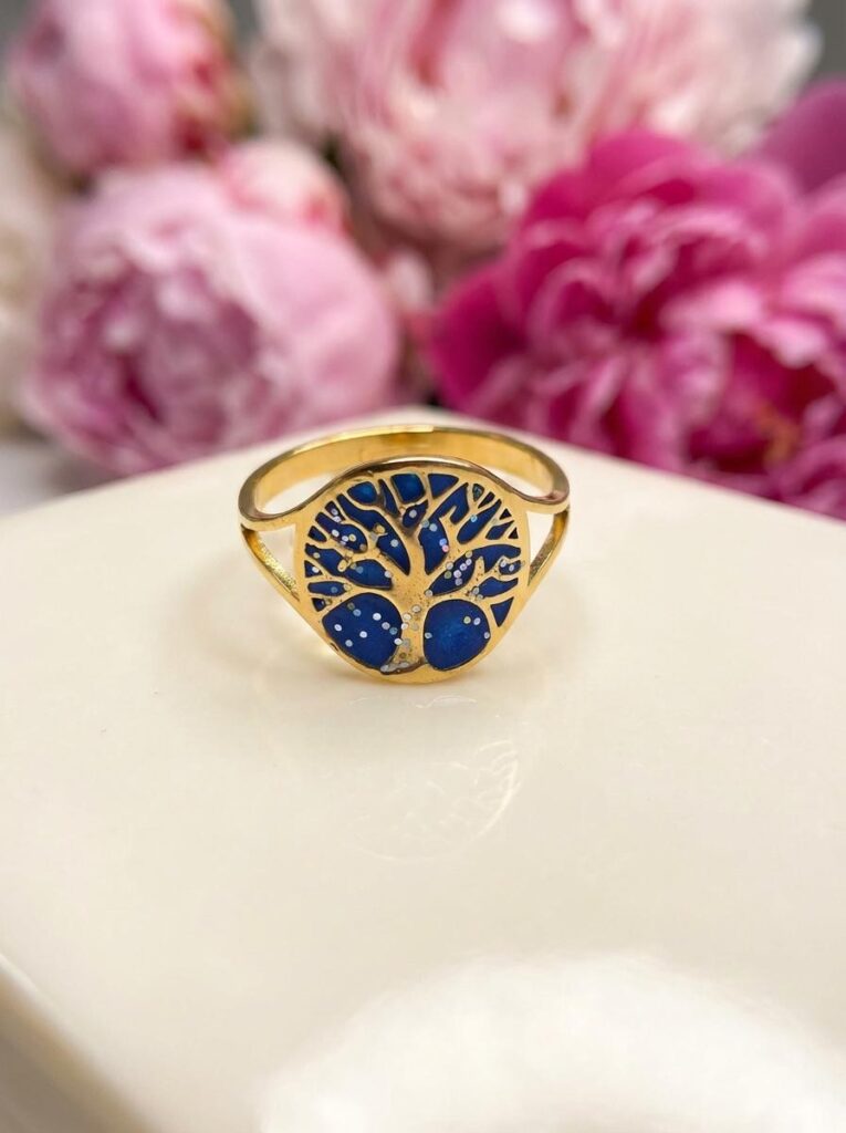 Bague Arbre de Lumière bleue pailletée Racine Céleste finition dorée posée sur table