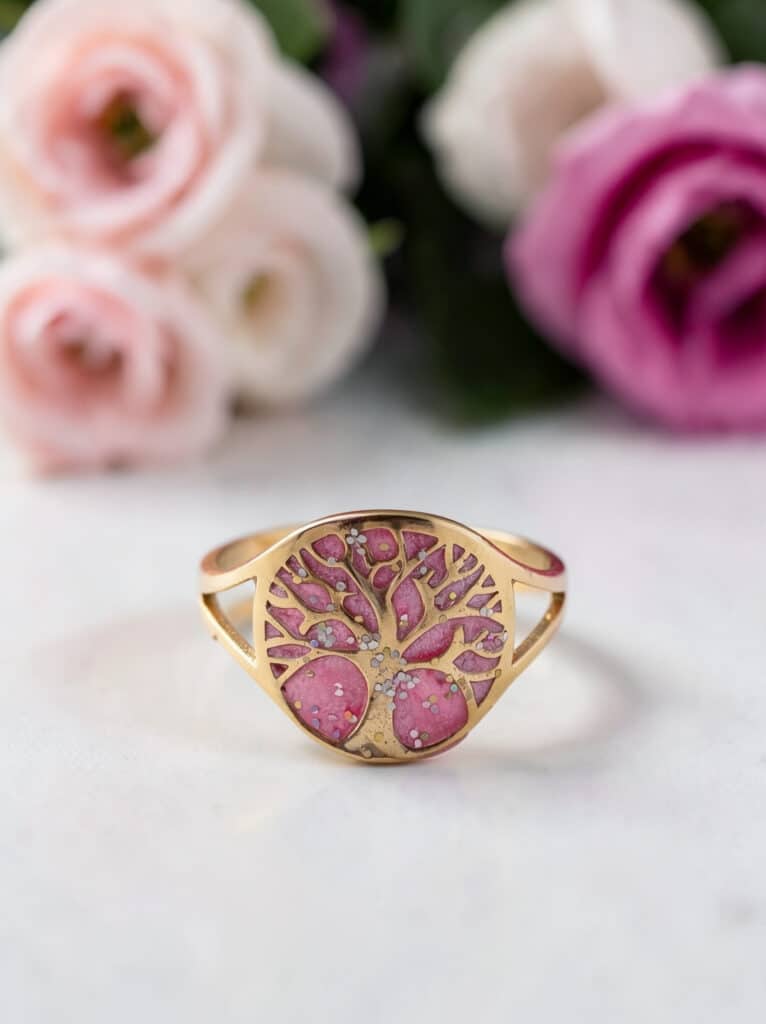 Bague Arbre de Lumière rose pailletée Floraison de Vie finition dorée posée sur table