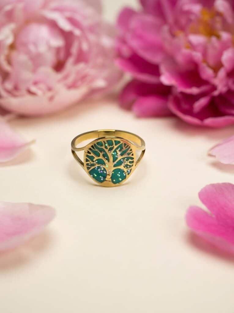 Bague Arbre de Lumière verte pailletée Sève de Vie finition dorée posée sur table