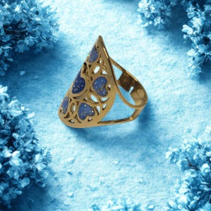 Bague Cœur en Lumière bleue pailletée Cœur Rayonnant finition dorée posée sur table