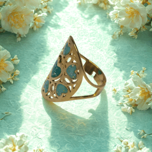 Bague Cœur en Lumière verte pailletée Cœur Florissant finition dorée posée sur table