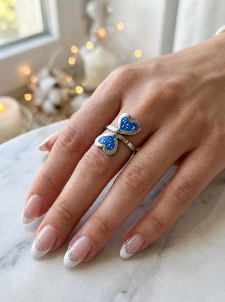 Bague duo Cœur en Lumière bleue pailletée Double Éclat finition argentée portée au doigt