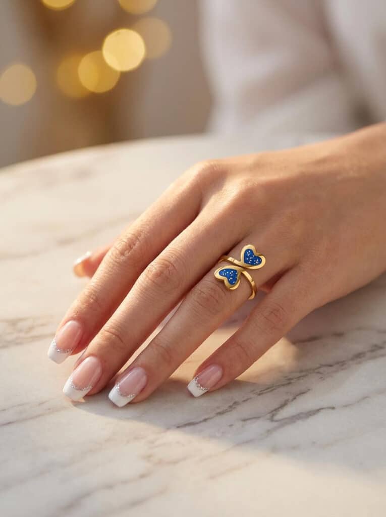Bague duo Cœur en Lumière bleue pailletée Double Éclat finition dorée portée au doigt
