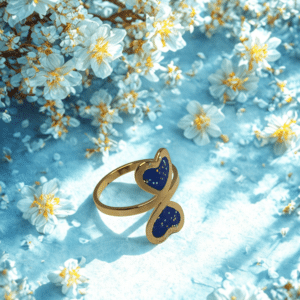 Bague duo Cœur en Lumière bleue pailletée Double Éclat finition dorée posée sur table