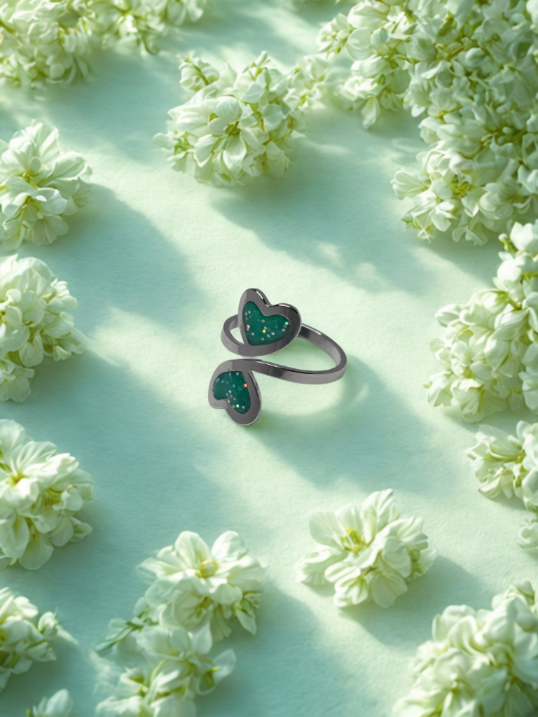 Bague duo Cœur en Lumière verte pailletée Double Nature finition argentée posée sur table