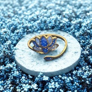 Bague Lotus Sacré bleu pailletée Lotus Céleste finition dorée posée sur table
