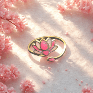 Bague Lotus Sacré rose pailletée Lotus Divin finition dorée posée sur table