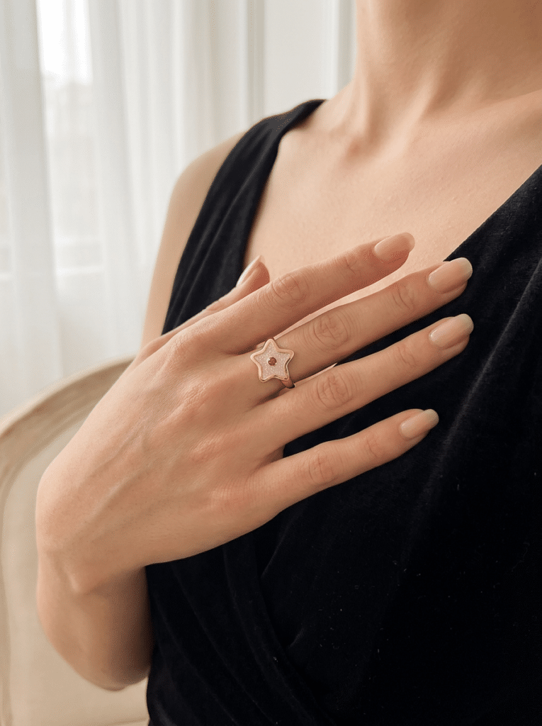 Bague Univers Étoilé rose pailletée Lueur Stellaire finition dorée portée au doigt