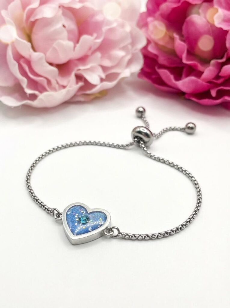 Bracelet Cœur en Lumière bleu pailleté Lueur du Cœur finition argentée posé sur table