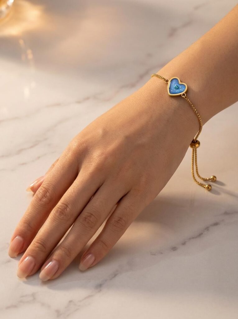 Bracelet Cœur en Lumière bleu pailleté Lueur du Cœur finition dorée porté au poignet