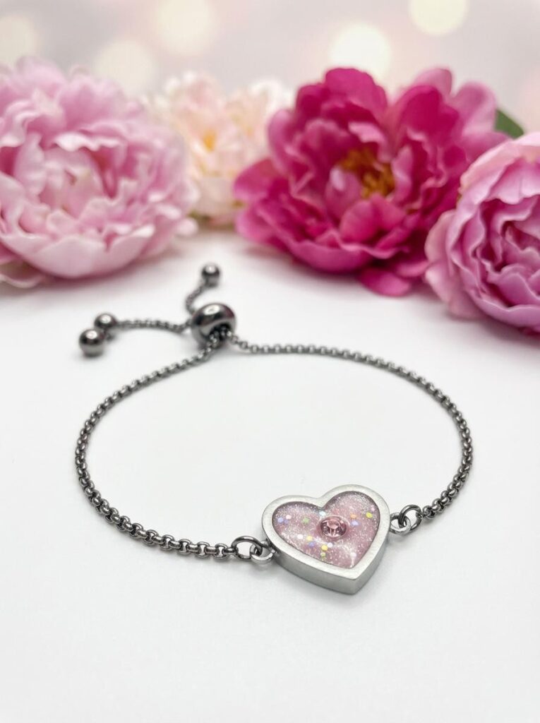 Bracelet Cœur en Lumière rose pailleté Douceur du Cœur finition argentée posé sur table
