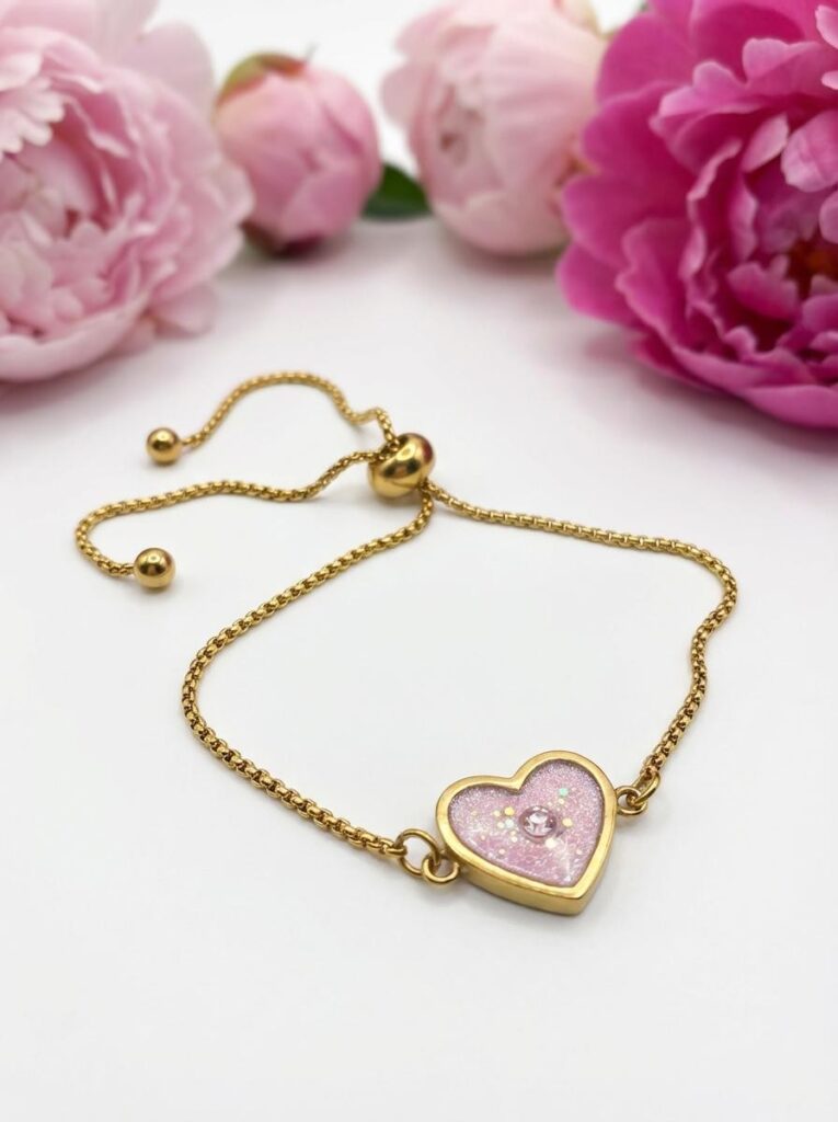 Bracelet Cœur en Lumière rose pailleté Douceur du Cœur finition dorée posé sur table