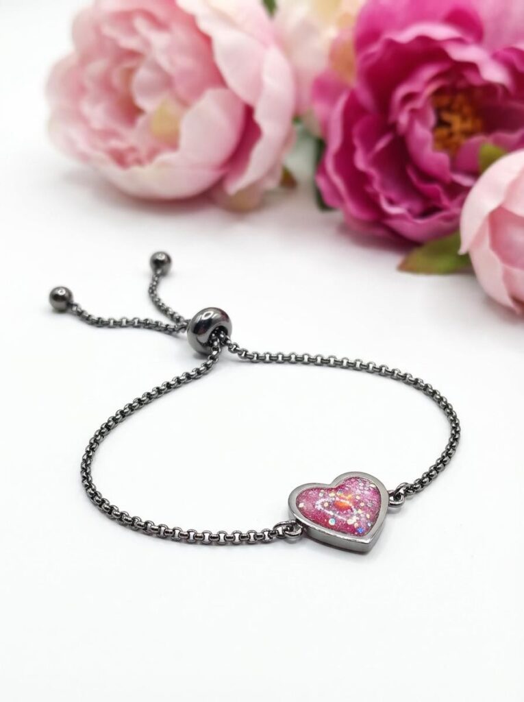 Bracelet Cœur en Lumière rouge pailleté Ardeur du Cœur finition argentée posé sur table