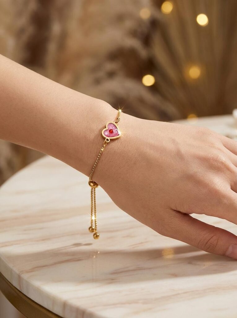 Bracelet Cœur en Lumière rouge pailleté Ardeur du Cœur finition dorée porté au poignet