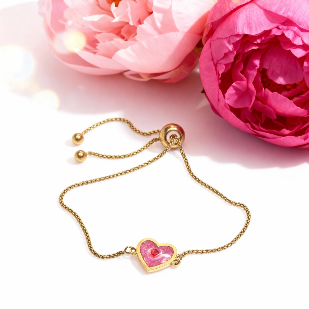 Bracelet Cœur en Lumière rouge pailleté Ardeur du Cœur finition dorée posé sur table