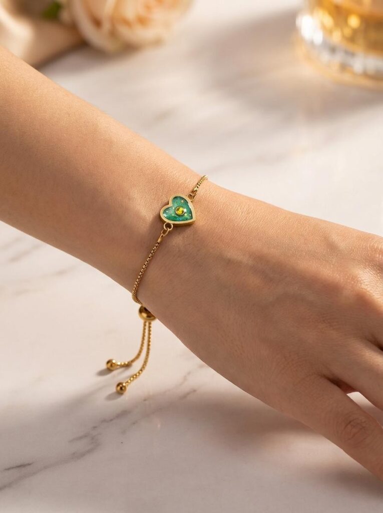 Bracelet Cœur en Lumière vert pailleté Éclat du Cœur finition dorée porté au poignet
