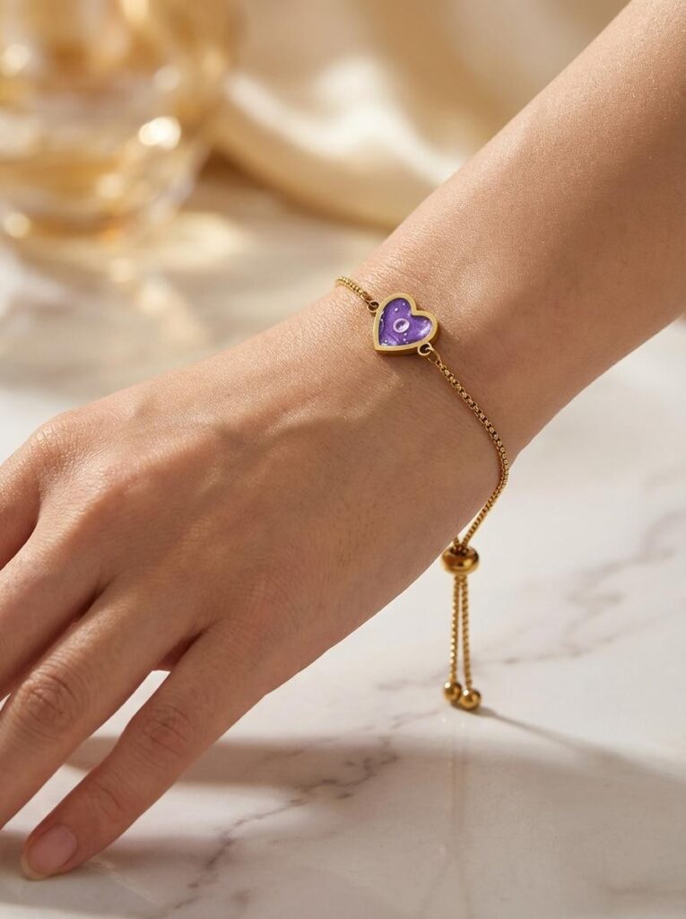Bracelet Cœur en Lumière violet pailleté Mystère du Cœur finition dorée porté au poignet