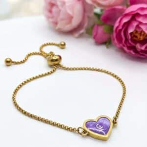 Bracelet Cœur en Lumière violet pailleté Mystère du Cœur finition dorée posé sur table