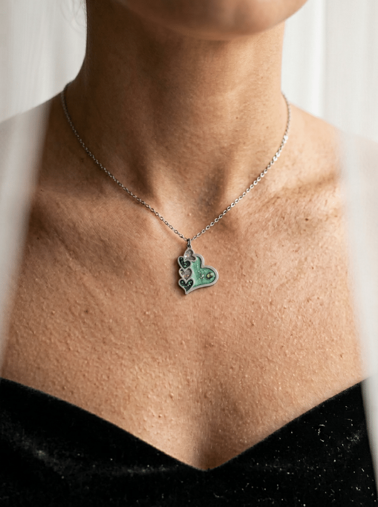 Collier Cœur en Lumière vert pailleté Cœur Émeraude finition argentée porté au cou