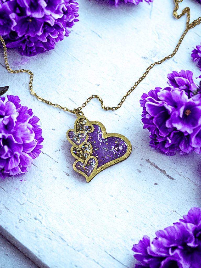 Collier Cœur en Lumière violet pailleté Cœur Mystique finition dorée posé sur table