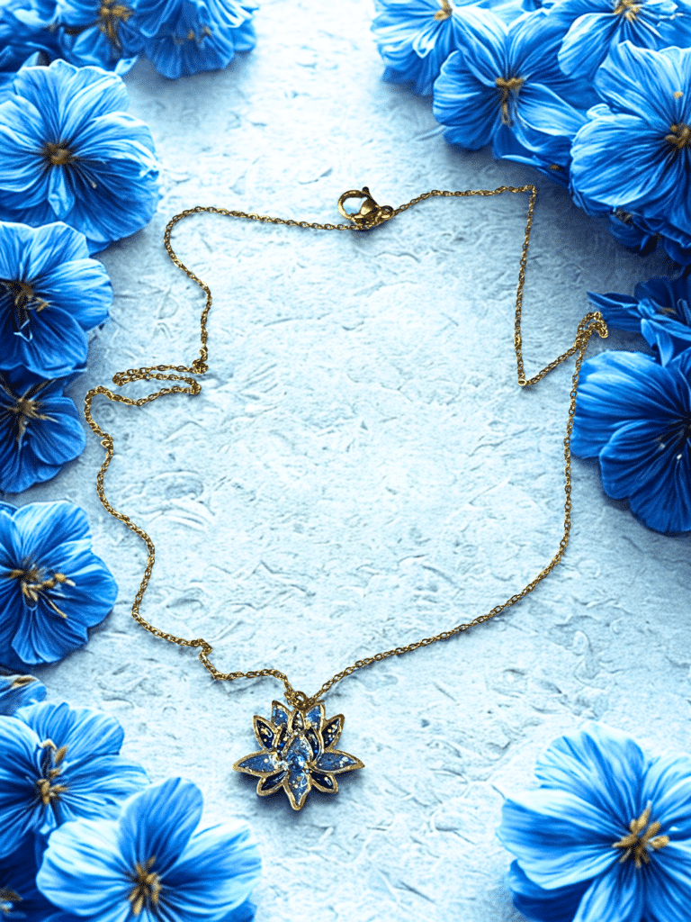 Collier Lotus Sacré bleu pailleté Sérénité Sacrée finition dorée posé sur table