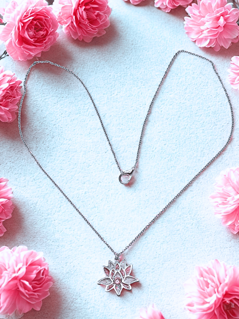 Collier Lotus Sacré rose pailleté Éclosion Divine finition argentée posé sur table