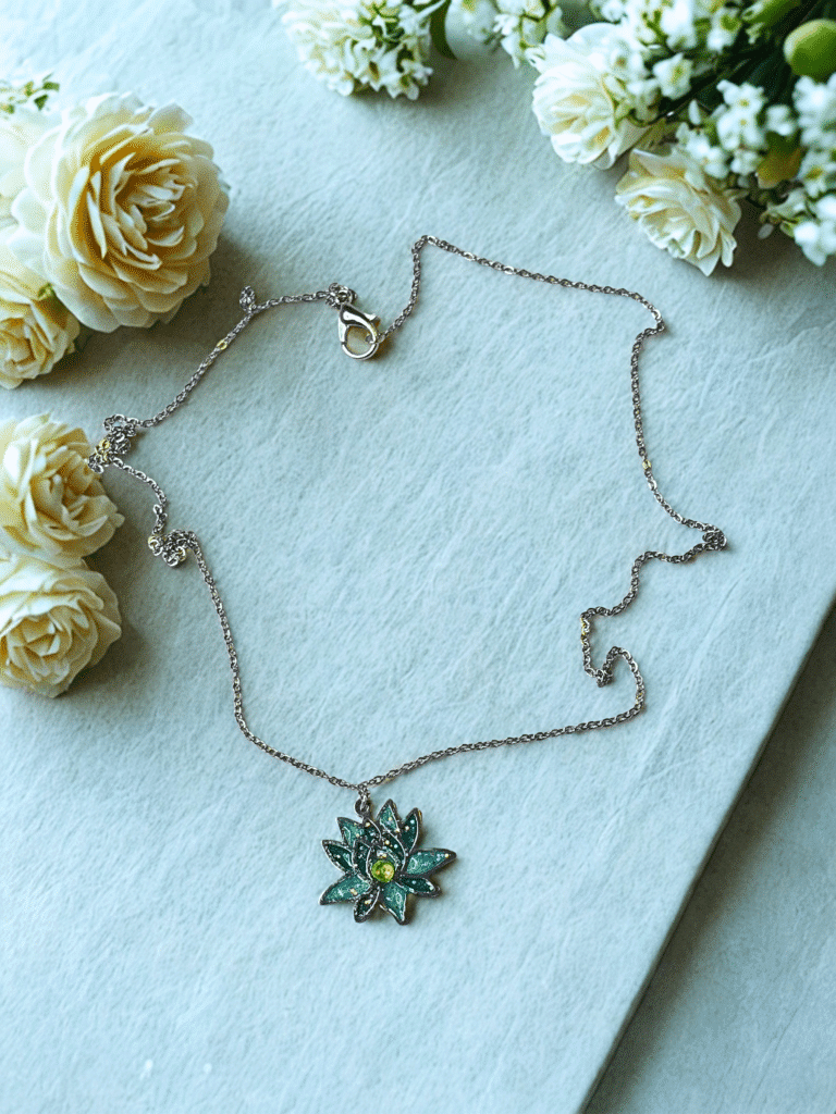 Collier Lotus Sacré vert pailleté Éveil Émeraude finition argentée posé sur table