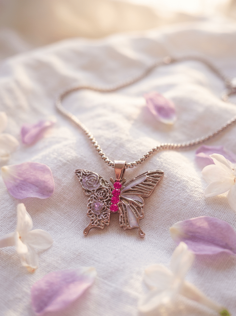 Collier Papillon Éternel argenté Envol Céleste posé sur tissu blanc avec pétales