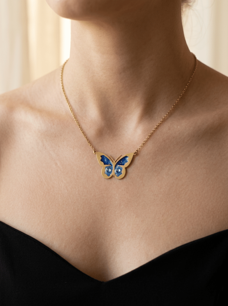 Collier Papillon Éternel bleu pailleté Aile Céleste finition dorée porté au cou