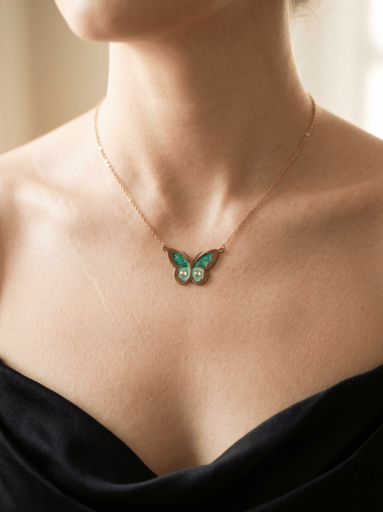 Collier Papillon Éternel vert pailleté Aile Émeraude finition dorée porté au cou