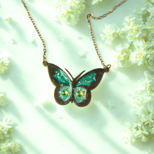 Collier Papillon Éternel vert pailleté Aile Émeraude finition dorée posé sur table